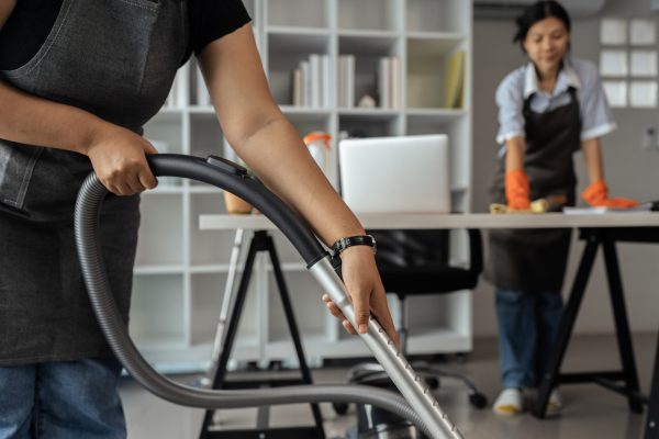 maid housekeeper service wear apron and vacuuming messy dirty floor for housekeeping housework and chores in house.